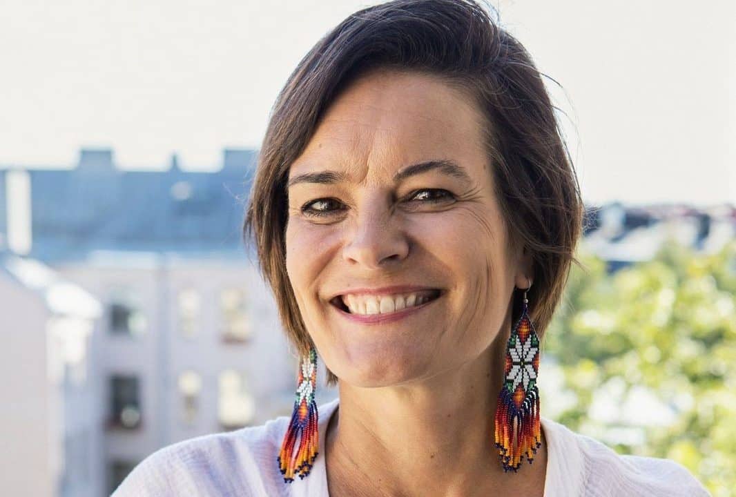 Kuvassa Hanna Jensen, jolla valkoinen pusero ja korvissa punaiset roikkuvat korvakorut.