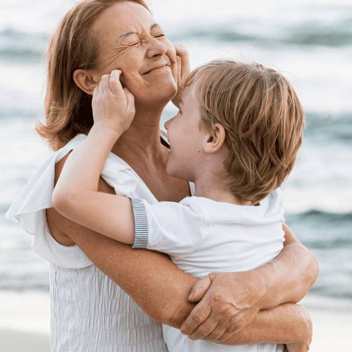 Muiden ihmisten seura hidastaa ikääntymisen vaikutuksia aivoihin. Kuvassa isoäiti ja lapsi leikkivät rannalla.